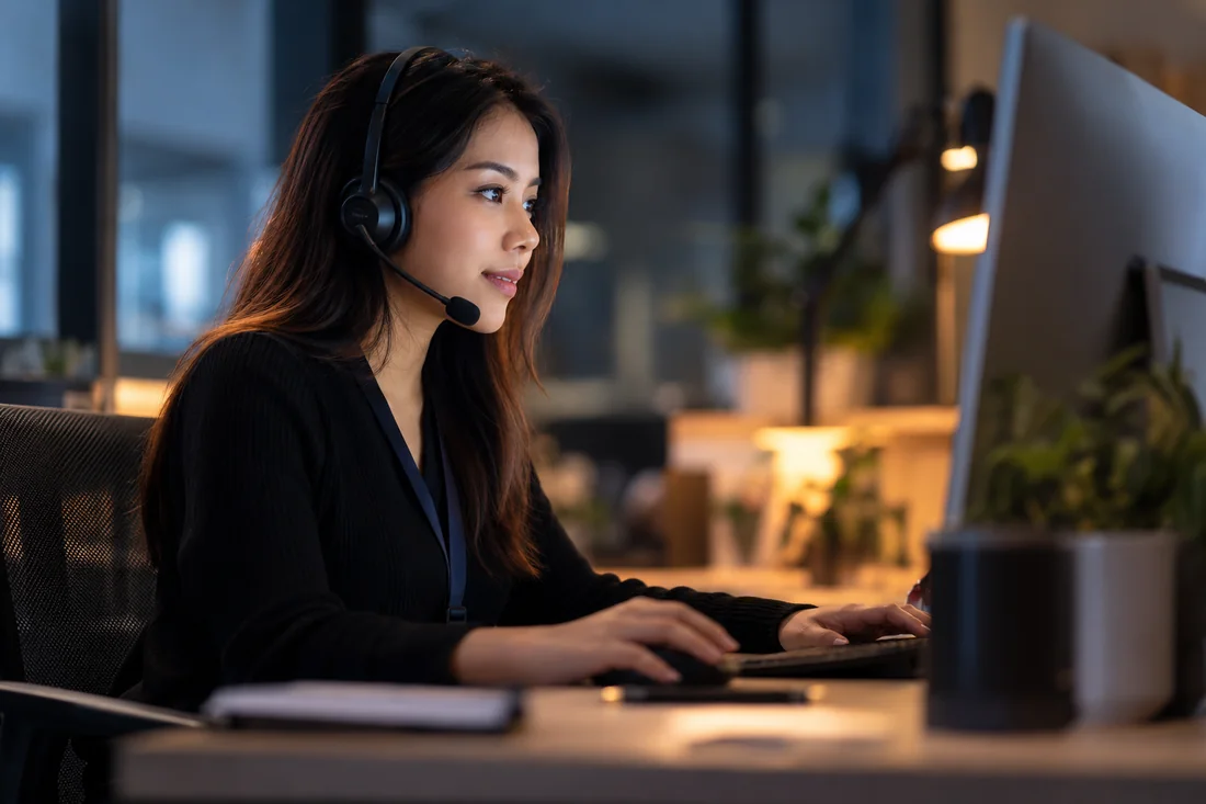Customer-service professional with a headset at a desk